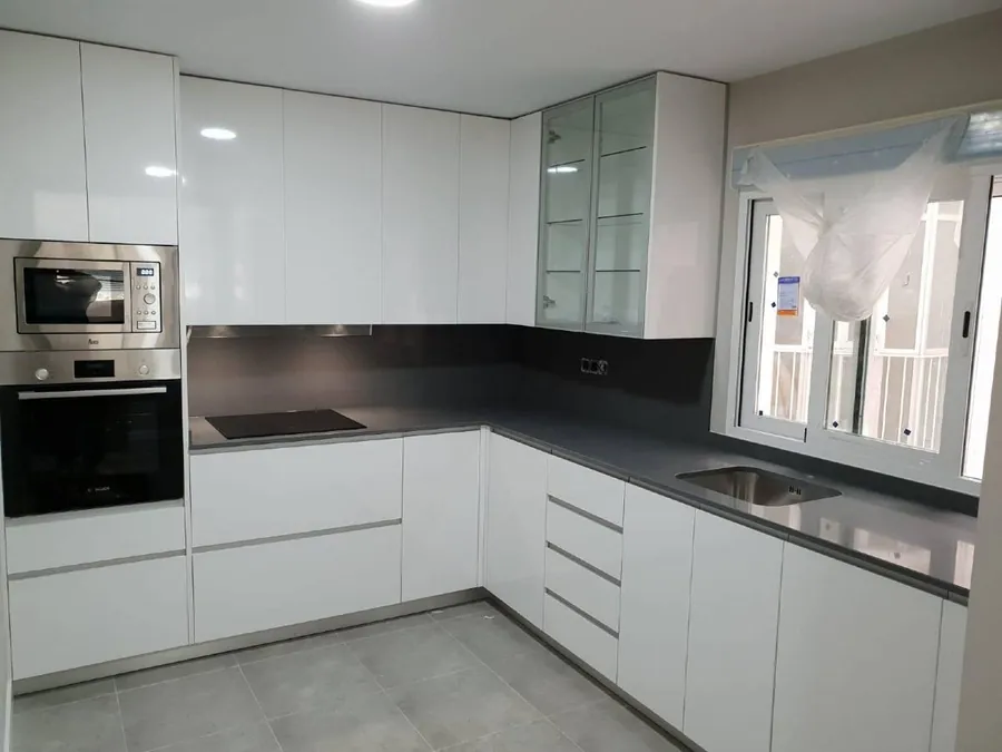 Cocina blanca reformada con encimera oscura