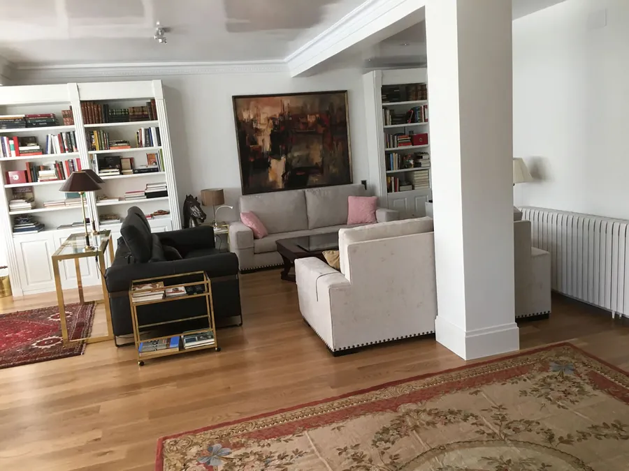 Salón reformado con suelo de parquet y estanterías
